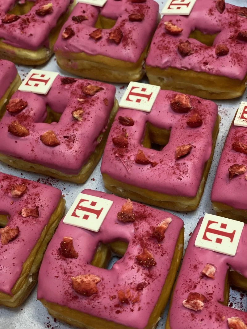 Square donuts with pink glaze, strawberry pieces and THE BOX logo toppers