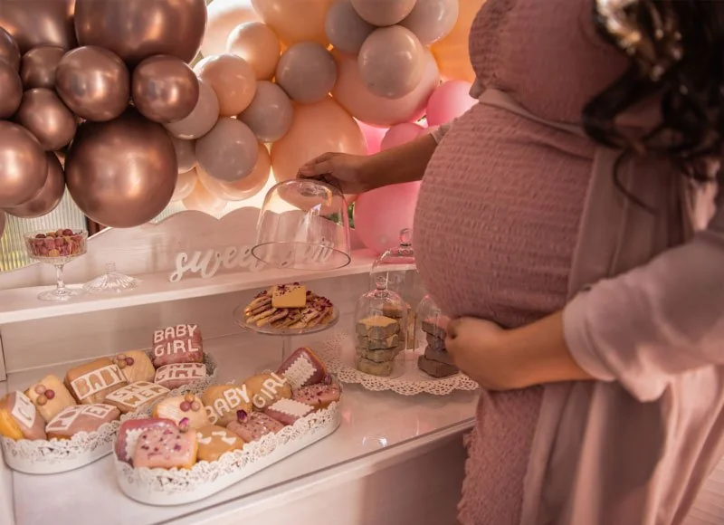Dessert table with sweets and balloon decor at a baby shower