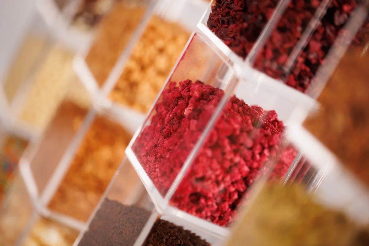 Glass boxes with freeze-dried raspberries, nuts and other donut toppings