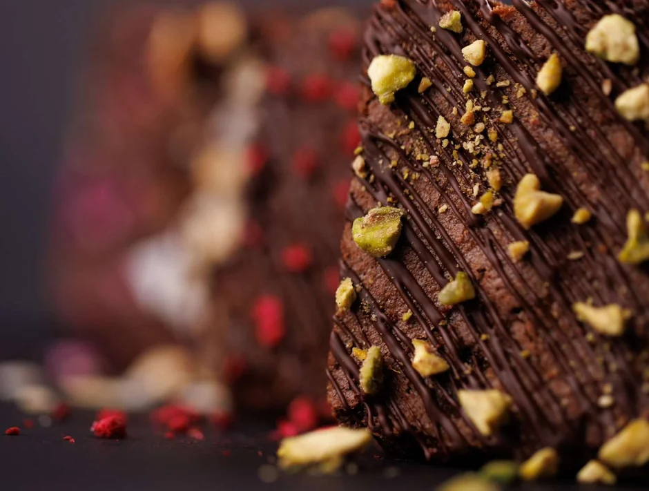 Square donut with chocolate glaze, chocolate shards and pistachio