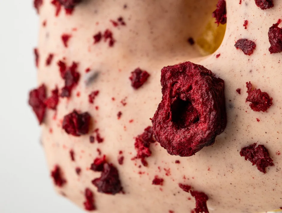 Square donut with pink cream, raspberries and cherry pieces